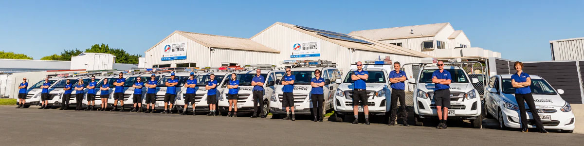 Picture of Hillmac Electrical staff lined up in front of their vehicles